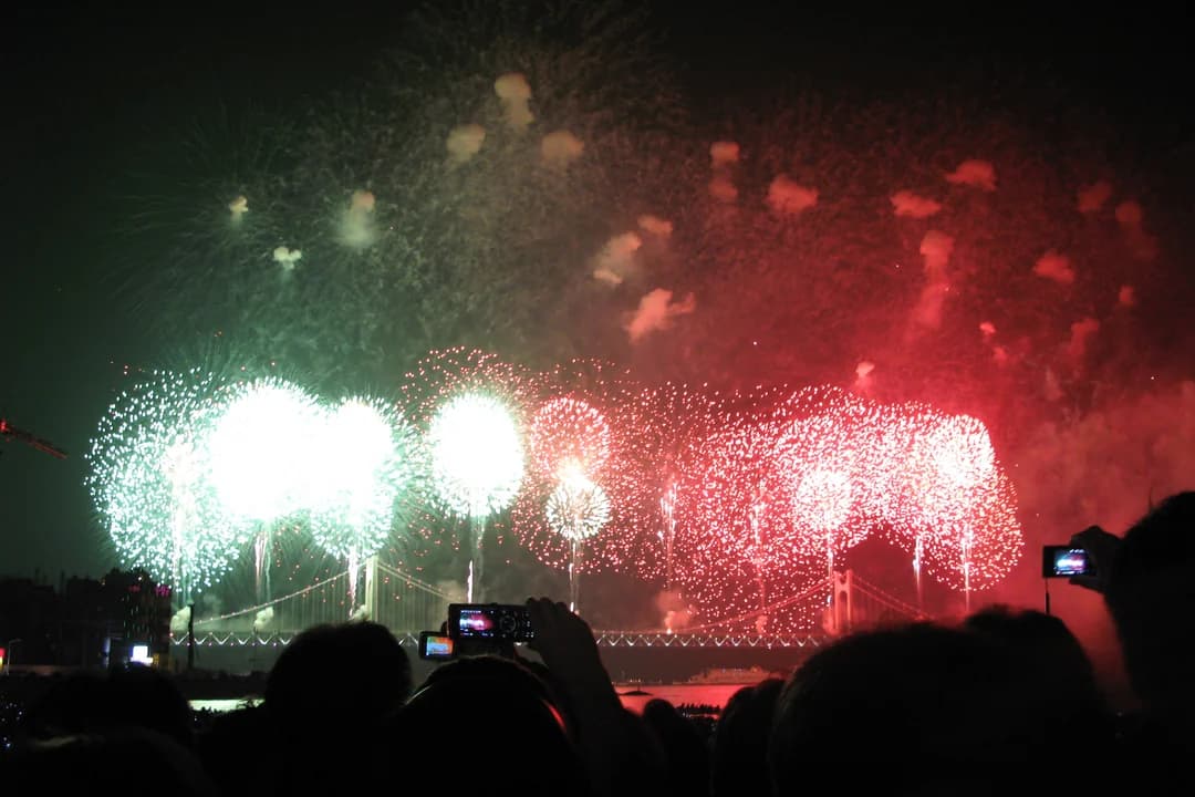 Green and red fireworks over the bay at the Busan Fireworks Festival, spectators only as silhouettes