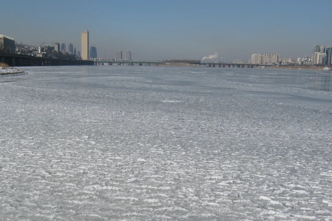 Ice floes on the frozen Han River in Seoul with the city skyline in the background